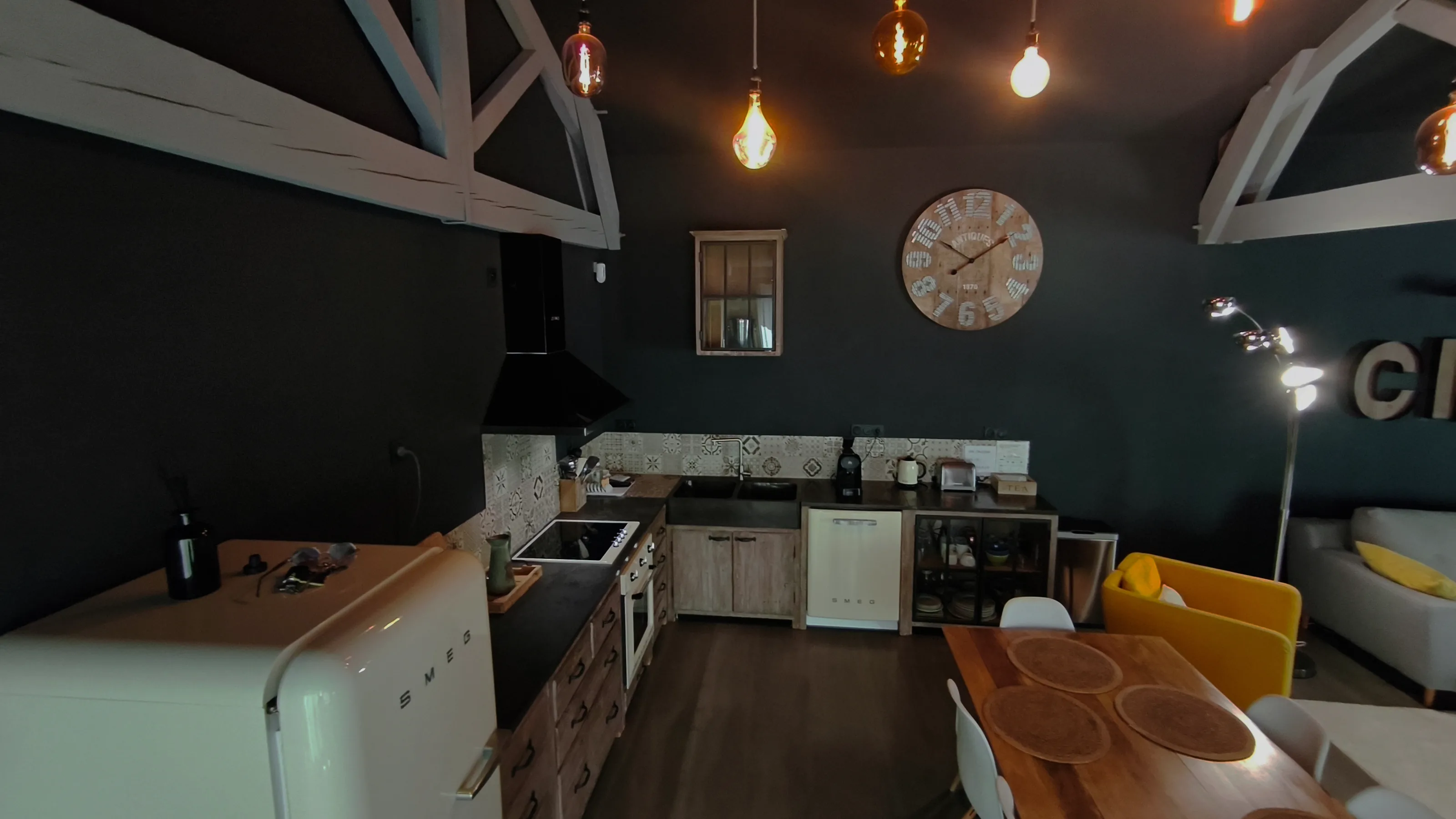 La cuisine : réfrigérateur crème, plan de travail sombre, carreaux de ciment